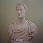 Close-up of a classical Roman statue bust displayed in a museum exhibit. — Julius Caesar The Man Who Changed Rome Forever