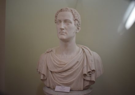 Close-up of a classical Roman statue bust displayed in a museum exhibit. — Julius Caesar The Man Who Changed Rome Forever