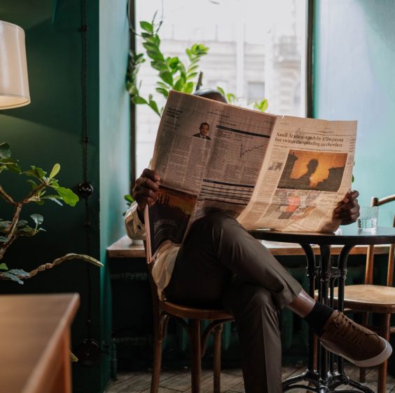 A man sits in a cozy café corner, enjoying a newspaper and relaxed ambiance. — KokoBet Casino: Quick Spin, Fast Wins & Instan