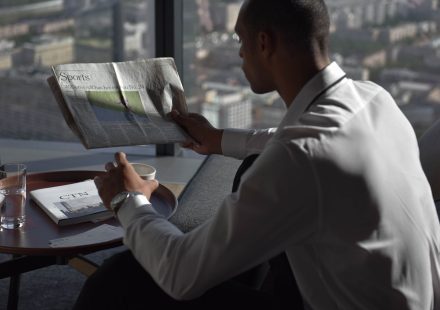Businessman in office reading sports section, enjoying coffee with city view. — Quelles sont les limites de mise au Magical S