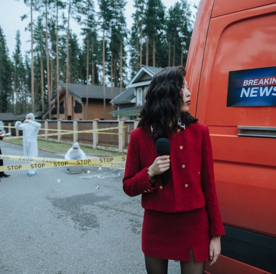 A reporter in red documents a crime scene with investigators in protective suits. — Wie nutze ich die Bonusangebote von Drago